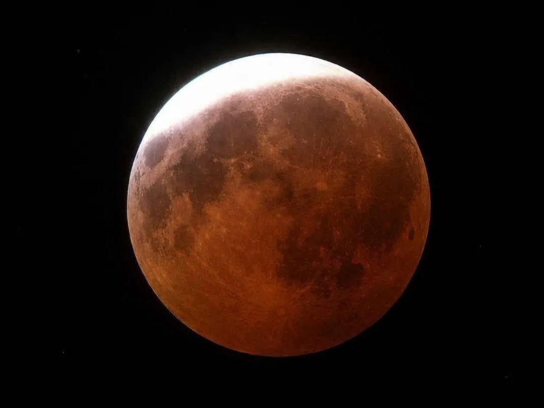 Skywatchers witness dramatic lunar eclipse reaching maximum shortly after midnight